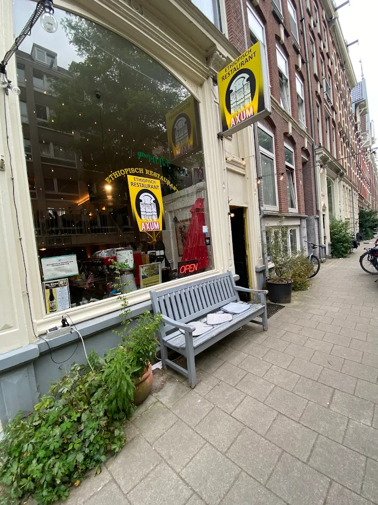 Axum restaurant storefront with distinctive yellow signage and welcoming entrance