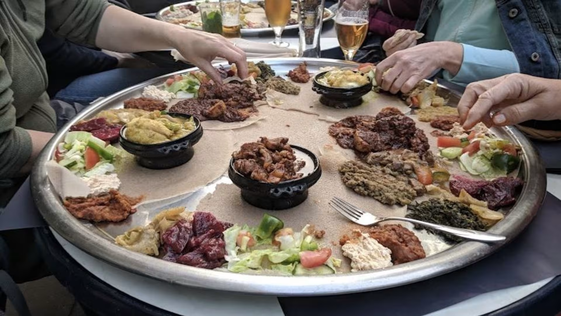 Guests sharing traditional Ethiopian meal in communal style