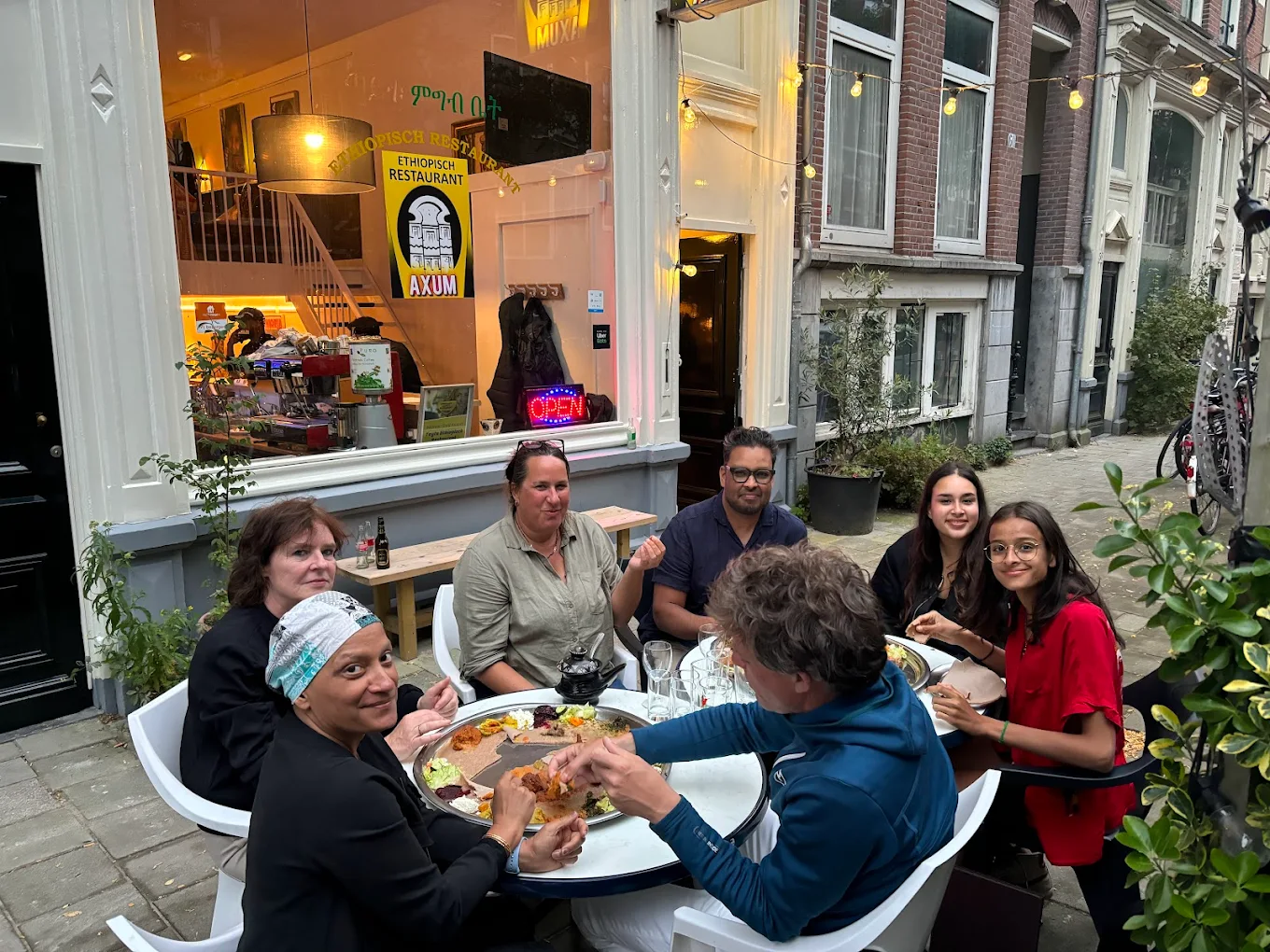 Happy customers enjoying authentic Ethiopian cuisine at Axum restaurant outdoor seating