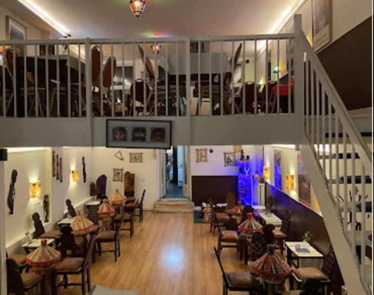 Two-level restaurant interior with mezzanine and traditional Ethiopian artifacts
